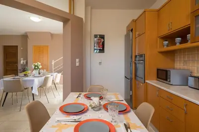 a kitchen and dining room with a table and chairs at Olive Tree Villa in Chania Town