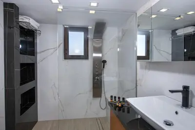 a white bathroom with a sink and a shower at Aretousa Home in Chania Town