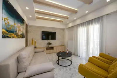 a living room with a couch and a tv at Aretousa Home in Chania Town
