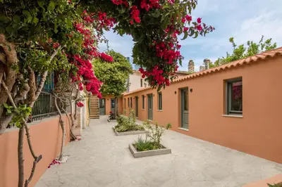 a courtyard of a house with pink flowers at Lindas Convent Garden Home 2 in Chania Town