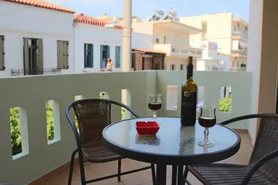 a table with two glasses of wine on a balcony at Anna Kavros appartment in Chania Town
