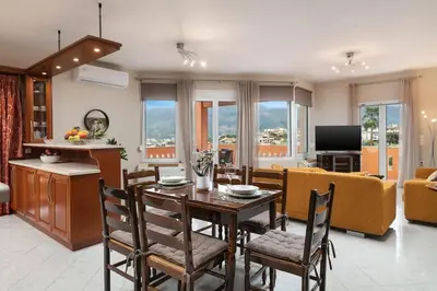 a kitchen and living room with a table and chairs at Villa Androniki in Souda