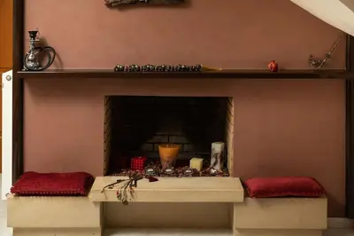 a fireplace with two benches in front of it at Villa Androniki in Souda