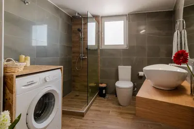 a bathroom with a washing machine and a toilet at Michail Suite Chania δίπλα στην παραλία της πόλης in Chania Town