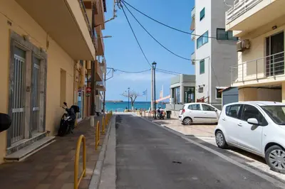 a white car parked on a street next to the beach at Michail Suite Chania δίπλα στην παραλία της πόλης in Chania Town