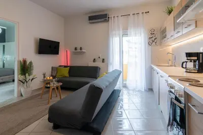 a kitchen and a living room with a couch and a table at Michail Suite Chania δίπλα στην παραλία της πόλης in Chania Town