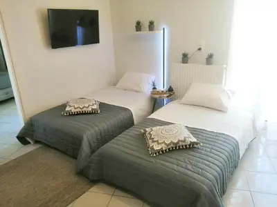 two beds sitting next to each other in a room at Michail Suite Chania δίπλα στην παραλία της πόλης in Chania Town