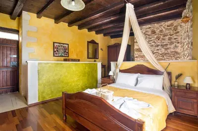 a bedroom with a bed with a mosquito net at Samonas - 5 maisonettes with breathtaking views in Chania Town