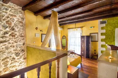 a room with a bed and a stone wall at Samonas - 5 maisonettes with breathtaking views in Chania Town