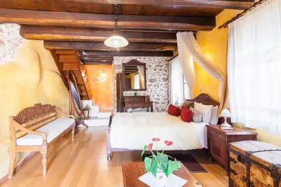 a bedroom with a bed and a couch and a table at Samonas - 5 maisonettes with breathtaking views in Chania Town