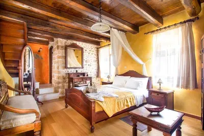 a bedroom with a bed and a table in a room at Samonas - 5 maisonettes with breathtaking views in Chania Town