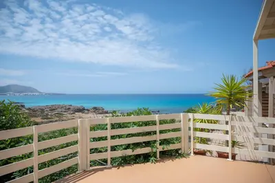 a white fence with the beach in the background at Elia Apartments in Falasarna