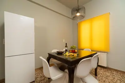 a dining room with a table and chairs and a yellow wall at ANMI Hospitality in Chania Town