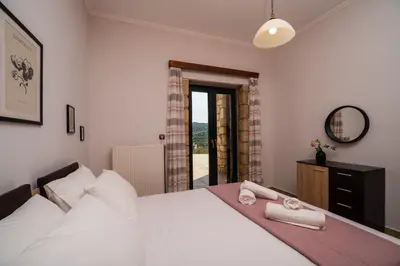 a bedroom with a white bed with towels on it at Agnadia Villa in Stalos
