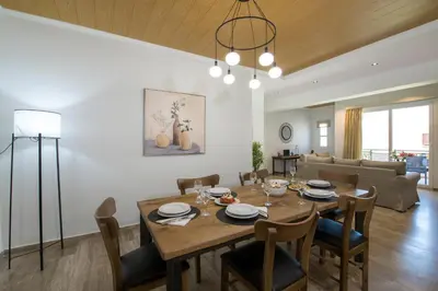 a dining room and living room with a table and chairs at G & E Apartment in Kissamos