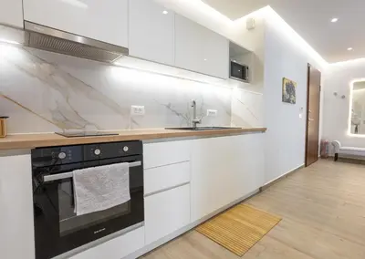 a kitchen with white cabinets and a stove top oven at Chania Memories in Chania Town