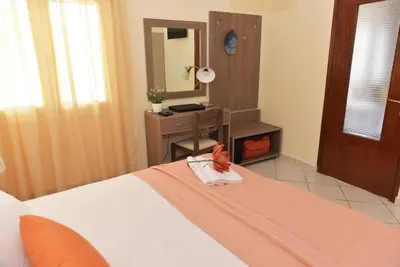 a bedroom with a bed with a desk and a mirror at Eleni's Σπίτι μπροστά στη θάλασσα in Daratso