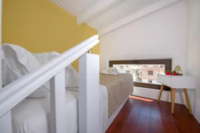a bedroom with a bed and a staircase with a window at Aretousa Studio in Chania Town