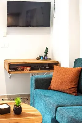 a living room with a blue couch and a flat screen tv at Ontas apartment in Kissamos in Kissamos