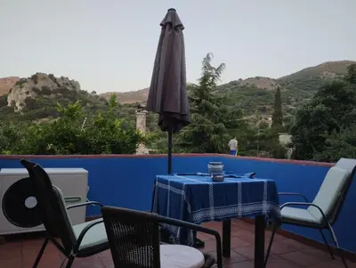 a table and chairs with an umbrella on a patio at Kastania..2 in Kiolianá