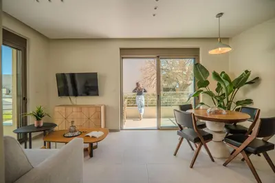 a living room with a table and chairs and a tv at Cozy Spot II near the beach in Ayiá