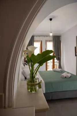 a vase with flowers on a table in a bedroom at Vesta suite&studio in Chania Old Town in Chania Town